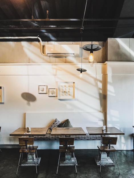 Foto sillas y mesa vacías en una habitación iluminada