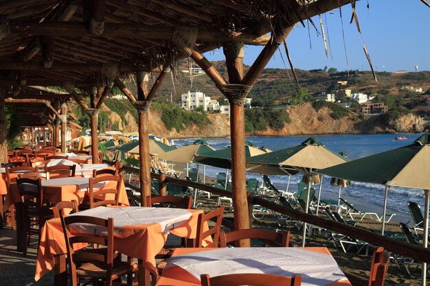 Sillas y mesas en un restaurante junto al mar