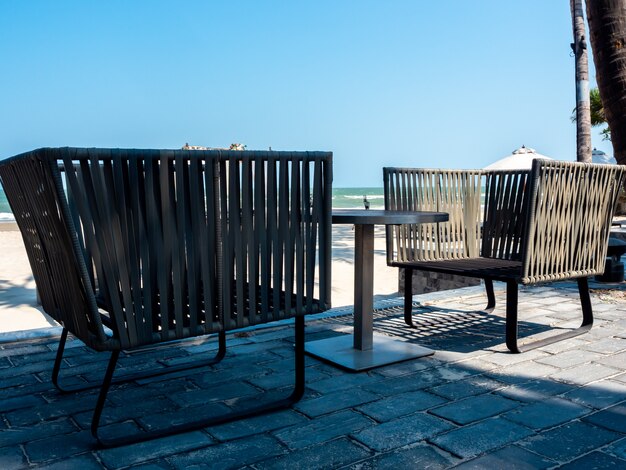 Sillas modernas con mesa auxiliar en el balcón con vista al mar