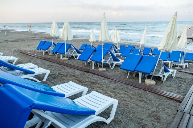 Sillas en la playa de arena cerca del mar