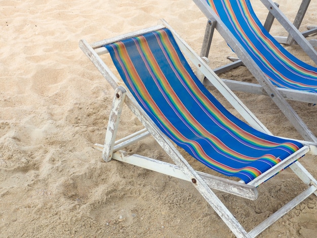 Sillas de playa de madera en la arena para unas vacaciones relajantes.