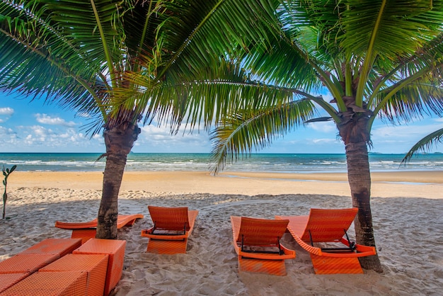 Sillas de playa y palmera de coco con fondo de cielo azul en la playa tropical durante el día