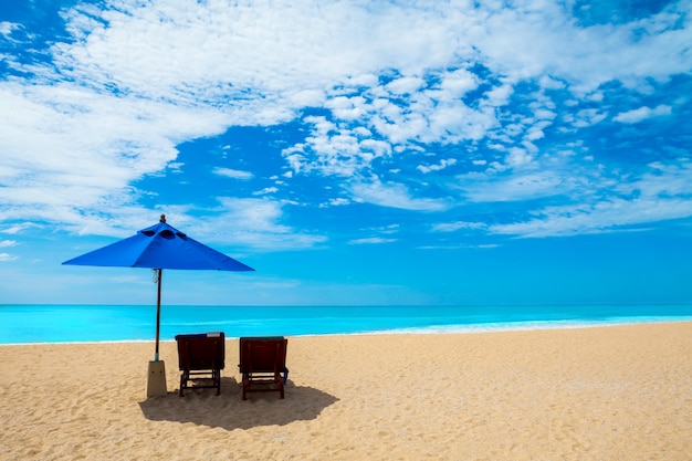 Sillas y sombrillas en una hermosa playa y cielo azul