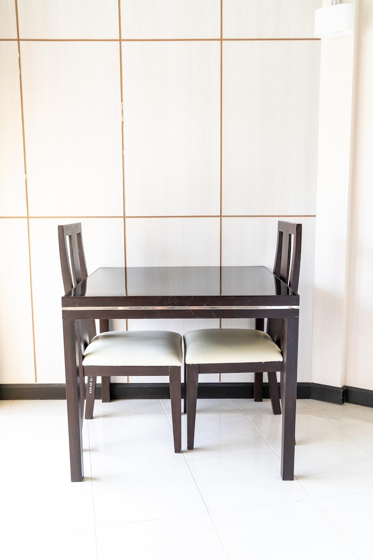 Foto sillas vacías y mesa contra la pared en casa
