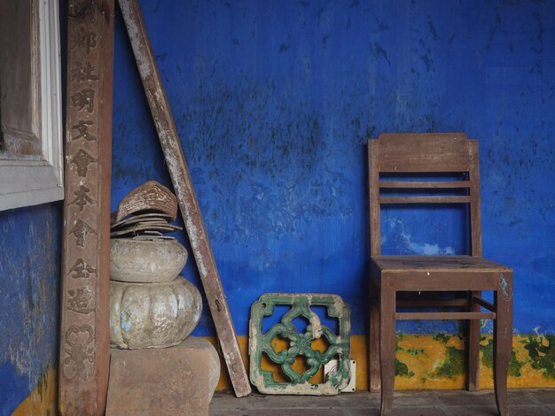 Foto sillas vacías y mesa contra la pared en un edificio antiguo