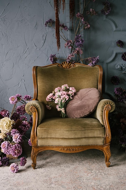 Sillón de madera vintage decorado con arreglos florales en el diseño interior de una casa de lujo