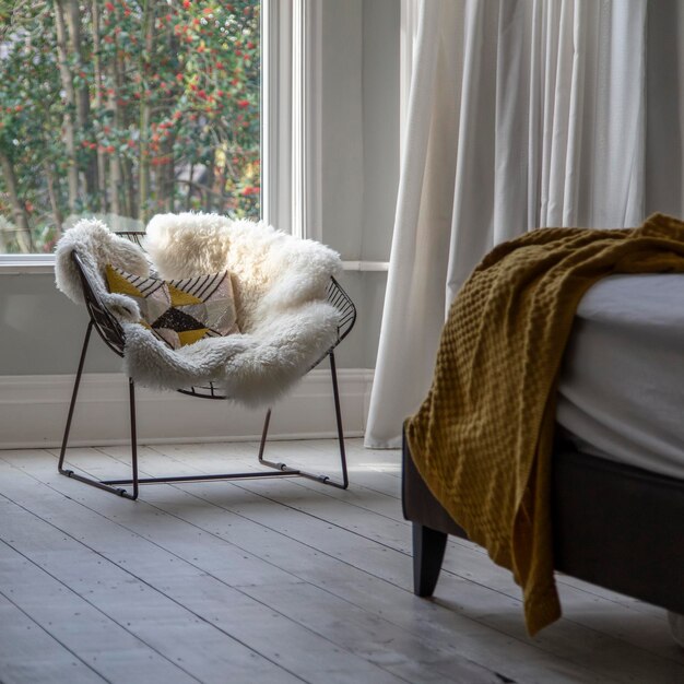 Sillón moderno cubierto con muebles suaves en un dormitorio luminoso