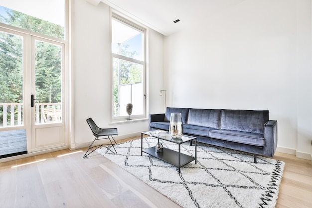 Sillones y sofás colocados alrededor de la mesa en el salón de luz de la casa moderna