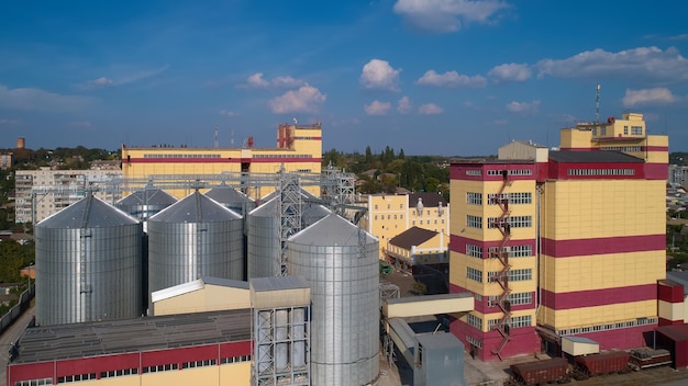 Silo agrícola Almacenamiento y secado de granos trigo maíz soja contra el cielo azul con nubes