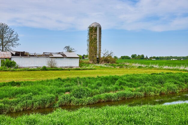 Silo verano cielo azul arroyo zanja hiedra verde trepando por el lado y el edificio antiguo