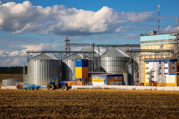 Silos Agrícolas Armazenamento e secagem de grãos trigo milho soja girassol contra o céu azul com nuvens brancasArmazenamento da colheita