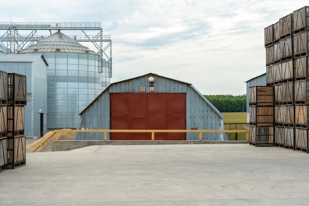 Silos de prata em filas de fábricas de agroindústrias de caixotes de madeira e paletes para armazenar e transportar frutas e legumes no armazém de produção do armazém