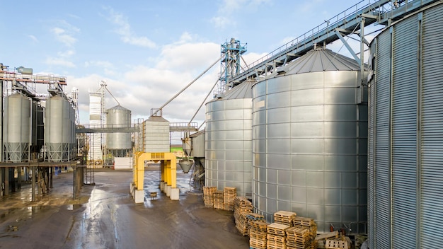 Silos de prata na planta de agroindústria para processamento de secagem, limpeza e armazenamento de produtos agrícolas, farinha, cereais e grãos Voando um drone sobre barris de ferro de grãos quadcopter photo