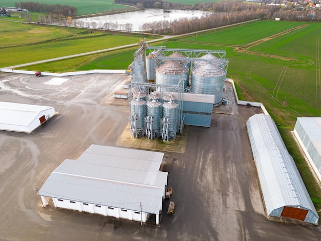 Silos de prata na planta de agroindústria para processamento de secagem, limpeza e armazenamento de produtos agrícolas, farinha, cereais e grãos Voando um drone sobre barris de ferro de grãos quadcopter photo