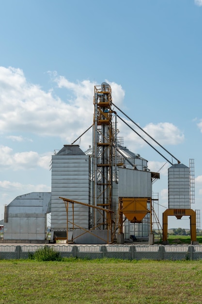 Silos de plata en la planta de fabricación agrícola para el procesamiento, secado, limpieza y almacenamiento de productos agrícolas, harina, cereales y granos Grandes barriles de hierro de grano Elevador de granero