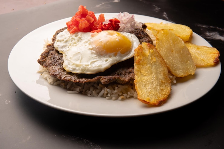 Silpancho comida tradicional Cochabamba Bolivia sobre un fondo negro