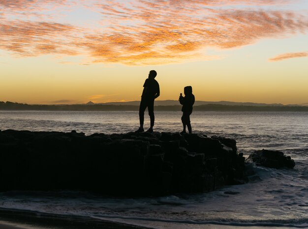 Silueta, de, amigos, tomar fotografía, en, ocaso, tiempo, en, un, roca, cerca, el, ocean., Amigos, concepto