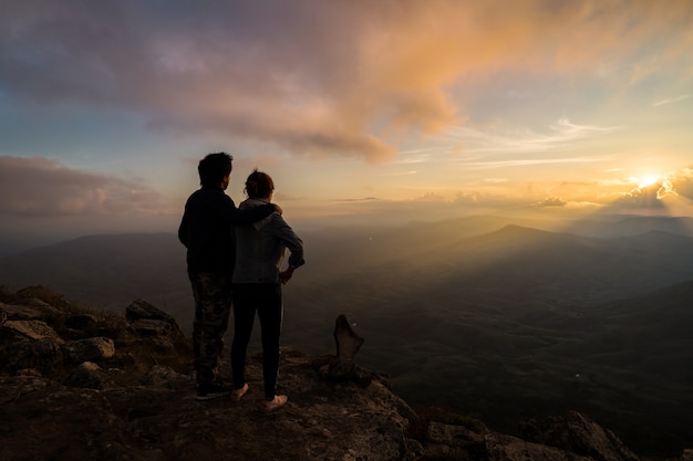 Silueta de amorosa pareja abrazándose en la montaña