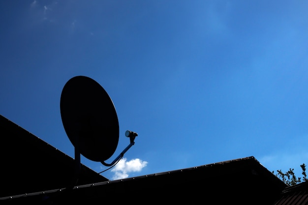 Foto silueta de antena parabólica con cielo azul