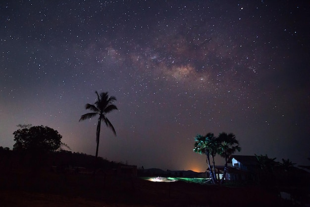 Silueta de árbol con casa y Vía Láctea fotografía de larga exposición