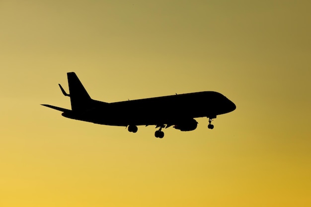 Foto silueta de avión en el cielo naranja al atardecer