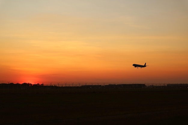 Silueta de un avión despegando hacia el cielo del atardecer