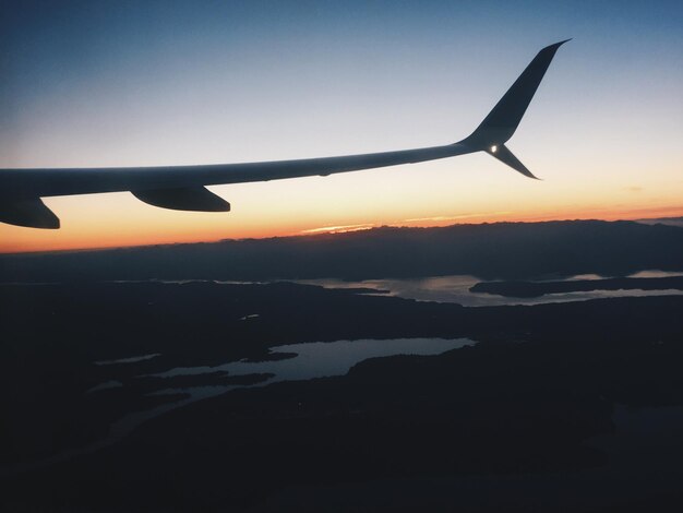 Silueta de un avión volando en el cielo al atardecer