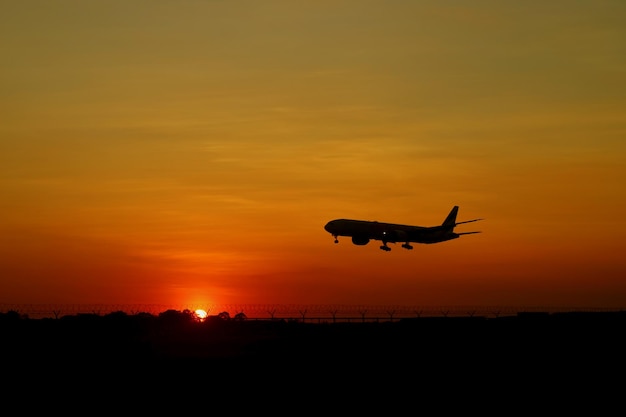 Silueta de avión volando en el hermoso cielo del amanecer