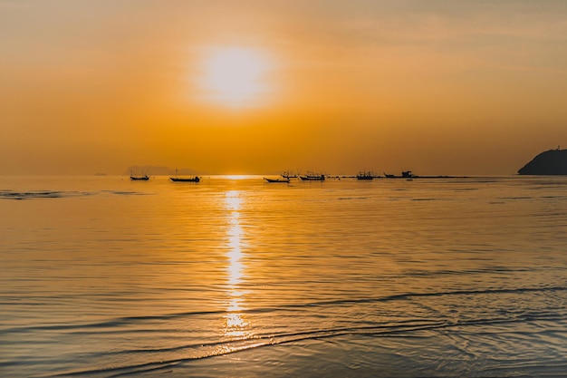 Silueta de barcos de pesca al atardecer en el mar