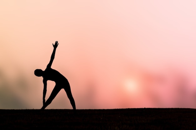 Foto silueta de una bella mujer de yoga al atardecer