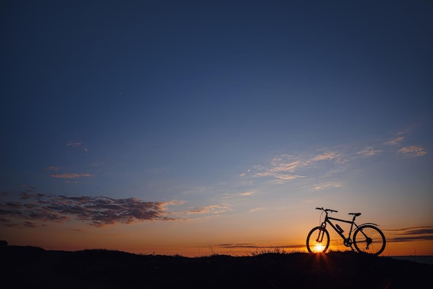 Silueta de una bicicleta en el cielo del atardecer