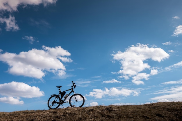 Silueta de bicicleta en cielo azul con nubes símbolo de independencia y libertad