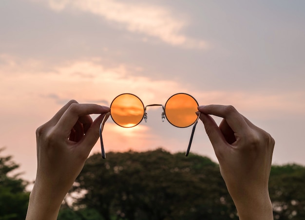 Silueta, borrosa, tono de arte de gafas de sol naranjas con fondo de cielo de noche