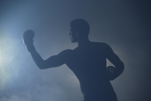 Silueta de boxeador masculino fuerte sobre fondo de color