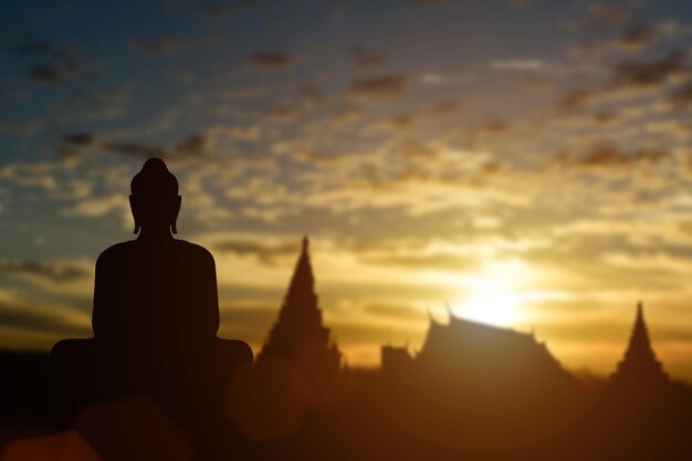 Foto silueta de buda en el fondo del atardecer del templo dorado atracción turística en tailandia