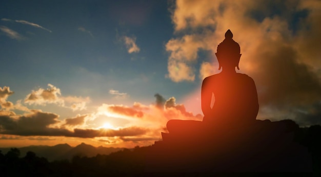 Silueta de Buda sobre fondo dorado atardecer creencias del budismo