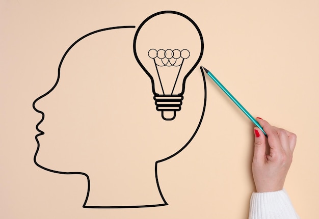 Silueta de una cabeza humana y un concepto de lámpara eléctrica de búsqueda de ideas creativas