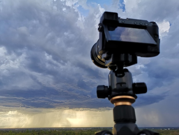 Silueta de la cámara en un trípode y el hermoso cielo de la tarde en el campo Atardecer con colorido cielo dramático en el campo