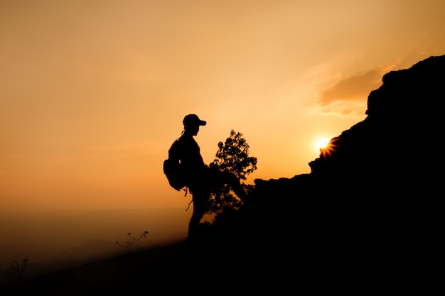 Silueta de un caminante de hombre en la cima de la colina