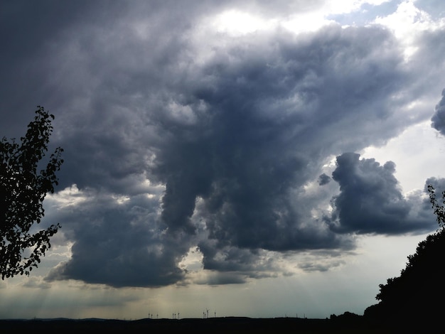 La silueta del campo y los árboles contra el cielo nublado