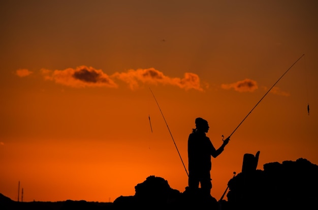 Silueta de caña de pescar pescador