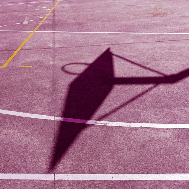 Silueta de canasta callejera en la cancha rosa.