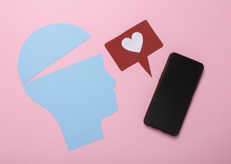 Silueta de la cara con icono de "me gusta" y teléfono inteligente en fondo rosa Adicción a las redes sociales
