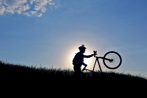 Silueta de un ciclista con una bicicleta al sol