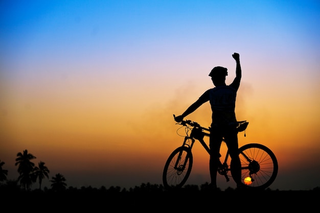 Silueta del ciclista con bicicleta de montaña en la hermosa puesta de sol.