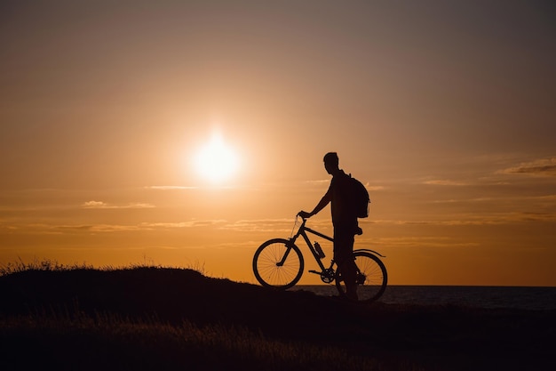 silueta, de, ciclista, en movimiento, en, hermoso, ocaso