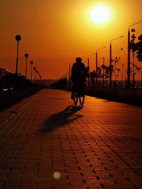 La silueta del ciclista se puede ver en la calle al atardecer