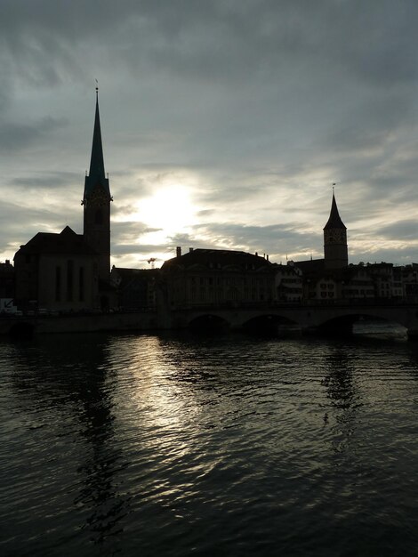 Foto silueta de la ciudad vieja de zúrich por la noche durante la puesta de sol en suiza en junio de 2010.