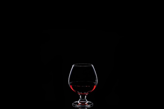 Silueta de cristal con vino tinto aislado en negro