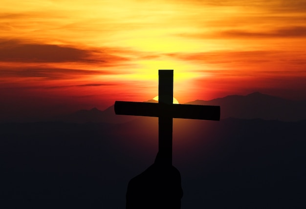 Silueta de la cruz religiosa contra un cielo del amanecer brillante Cruz con el concepto de Jesucristo de la Biblia